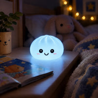 Veilleuse Dumpling bleue allumée sur une table de nuit